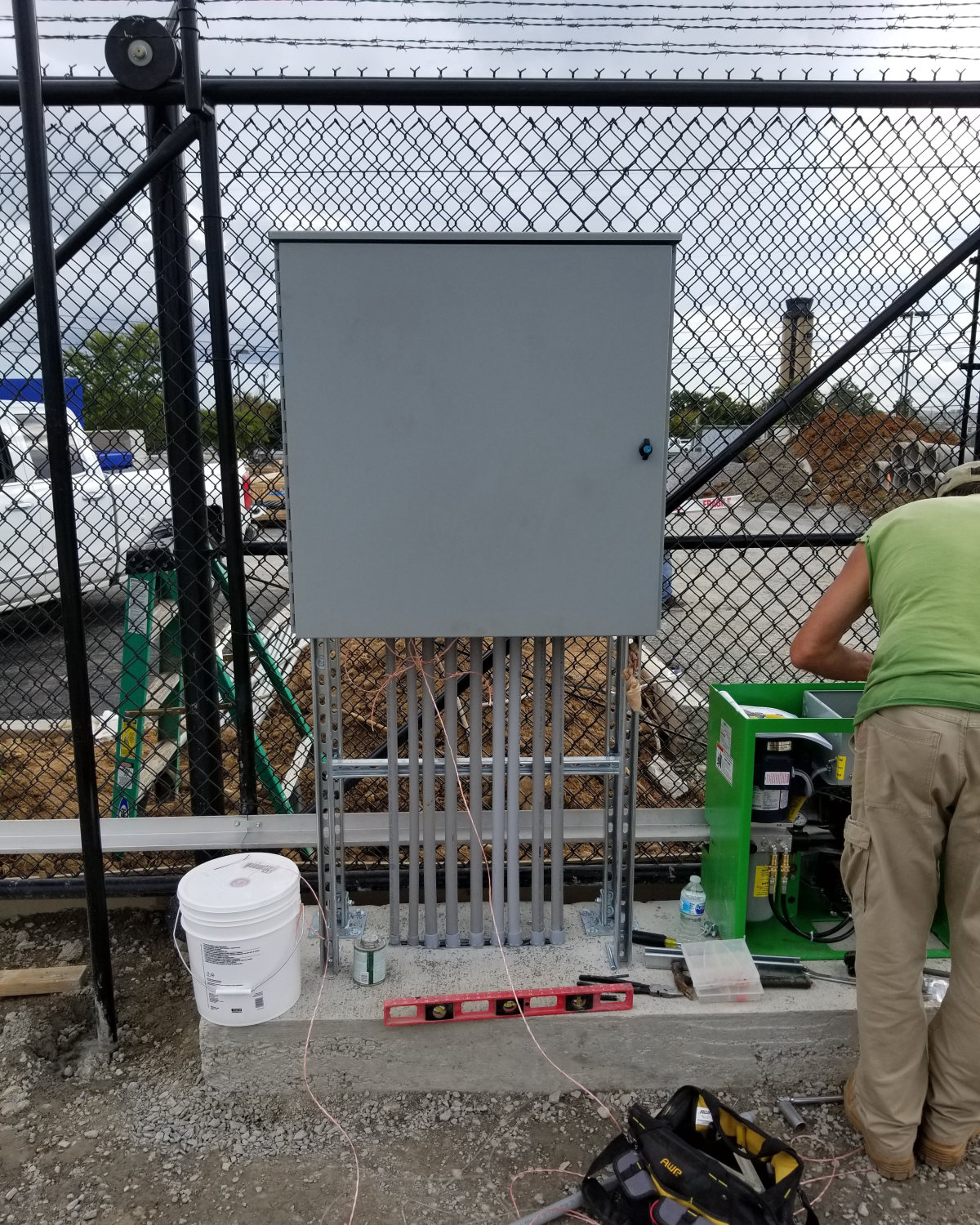 Amprite electrician installing a commercial transfer switch and generator connection on a concrete pad