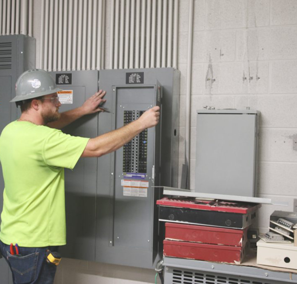 Amprite electrician troubleshooting a panelboard during a service call