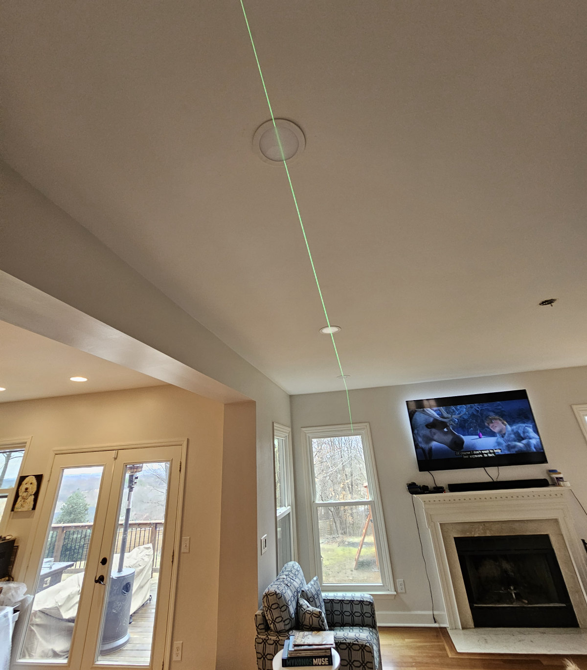Laser level marking recessed light placement on a ceiling before installation by Amprite electricians