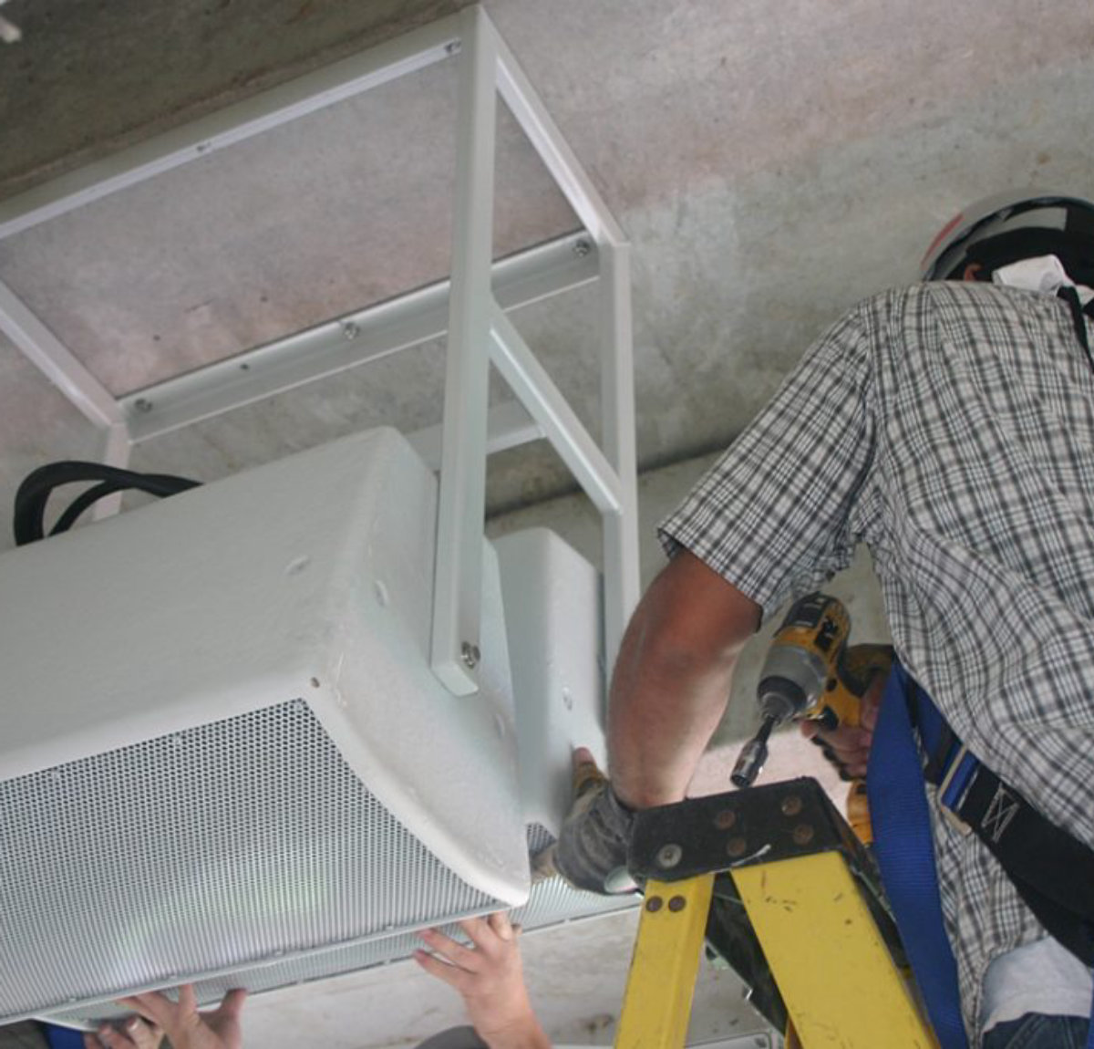 Amprite technician installing low-voltage speaker and signal cabling