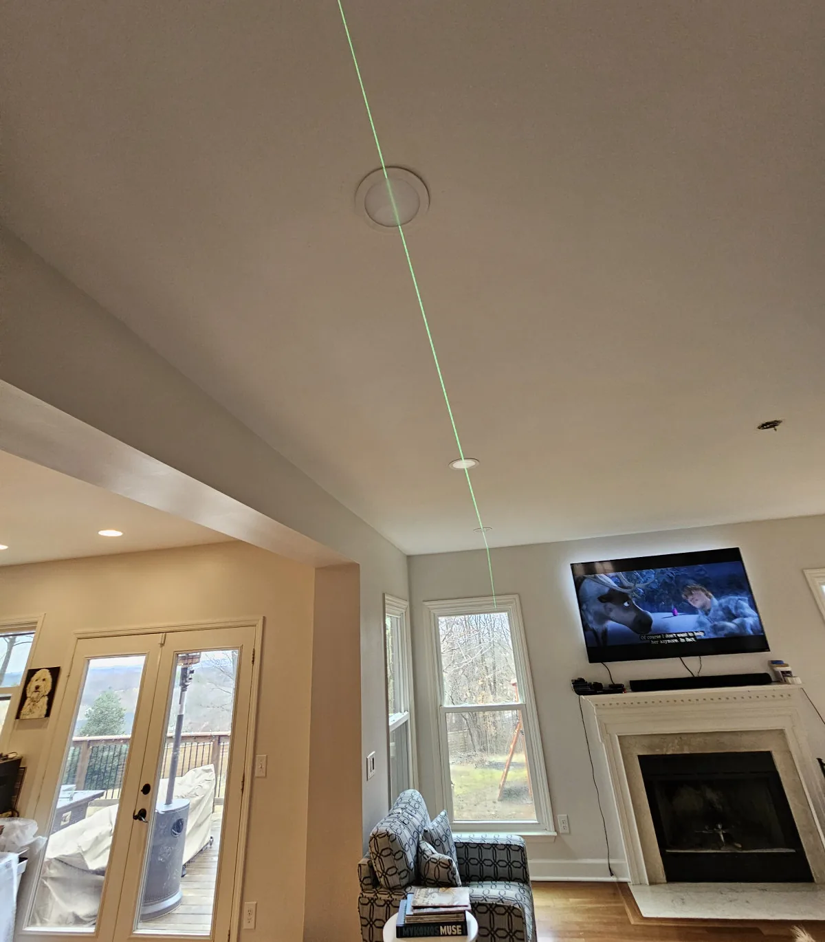 Laser level marking recessed light placement on a ceiling before installation by Amprite electricians