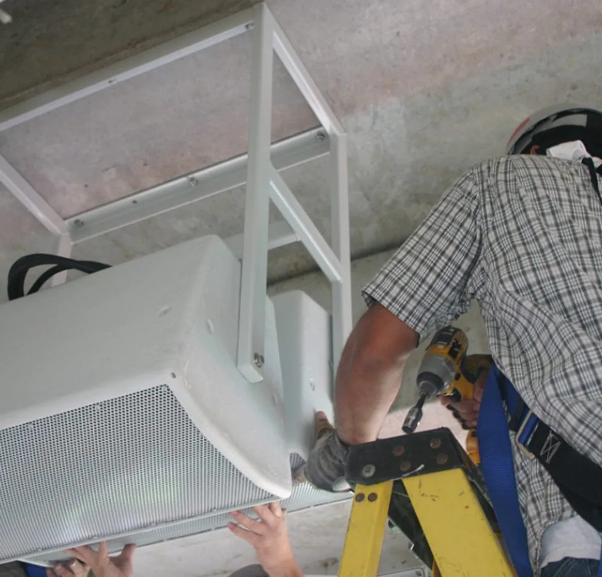 Amprite technician installing low-voltage speaker and signal cabling